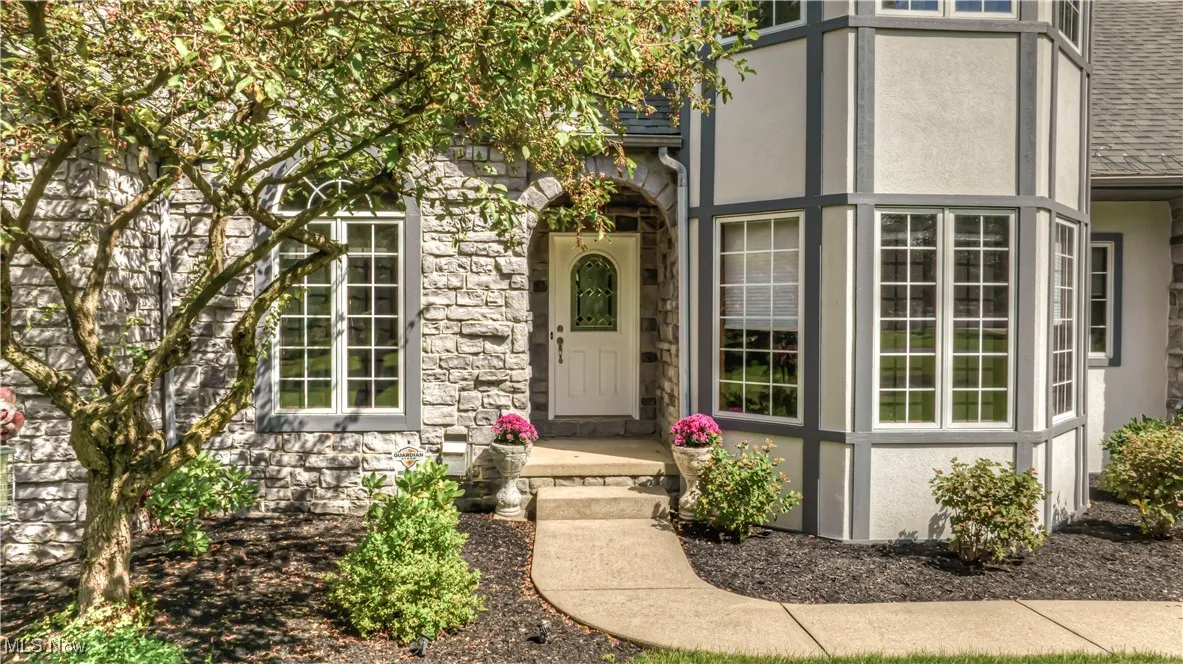 Entrance to property with stone siding and stucco siding