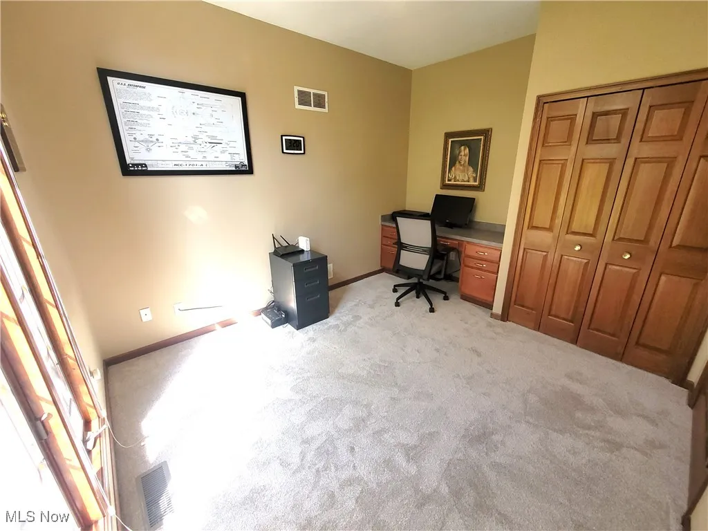 Home office featuring light colored carpet and baseboards