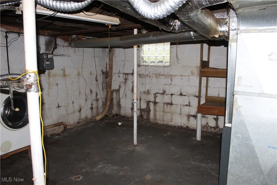 Below grade area with heating unit and washer / clothes dryer