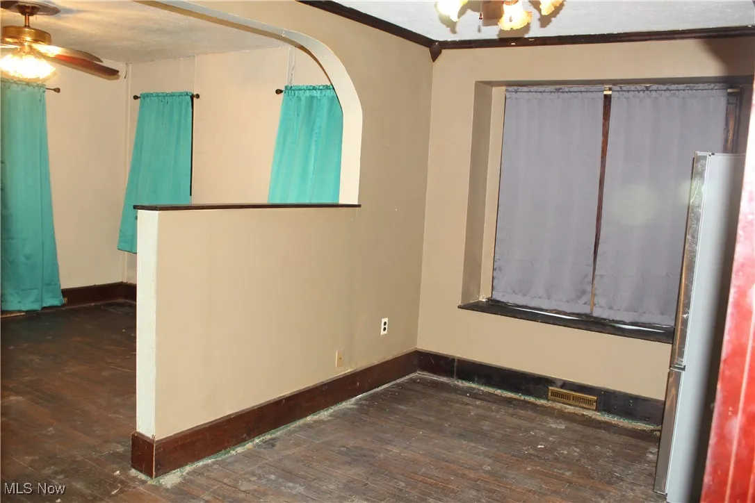 Diningroom featuring ceiling fan, dark wood-type flooring, crown molding, and a textured ceiling