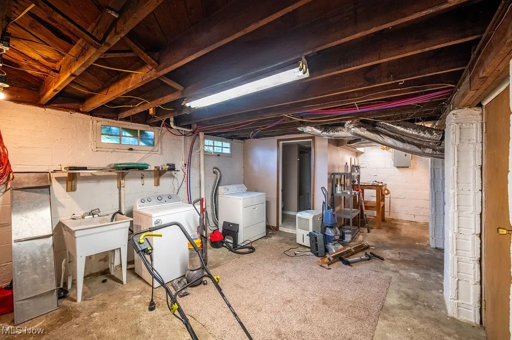 Below grade area featuring washing machine and clothes dryer and a sink