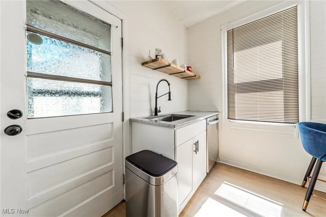 Kitchen with white cabinets, open shelves, dishwasher, and light wood finished floors