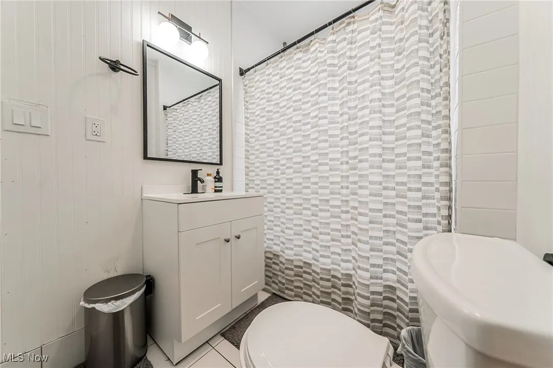 Bathroom with light tile patterned flooring, vanity, and a shower with curtain