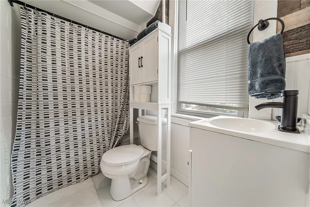 Bathroom featuring light tile patterned flooring, vanity, and a shower with curtain