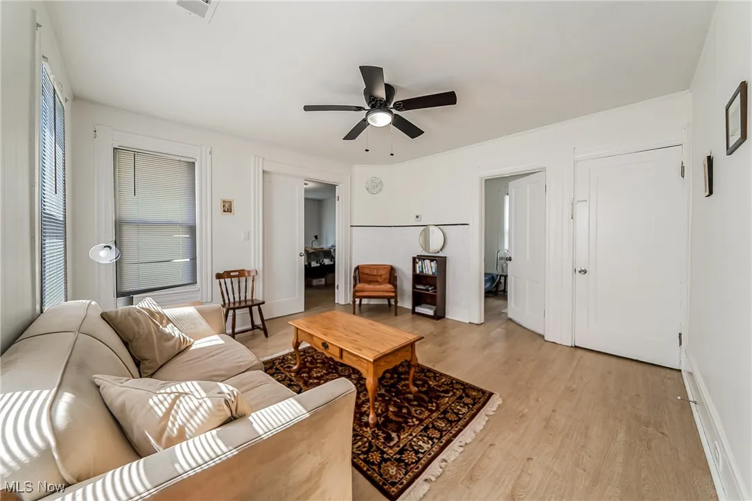 Living area featuring light wood-type flooring and ceiling fan