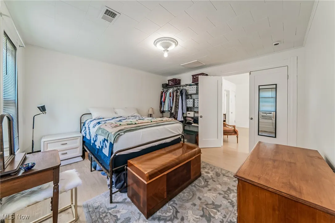 Bedroom featuring light wood finished floors and attic access