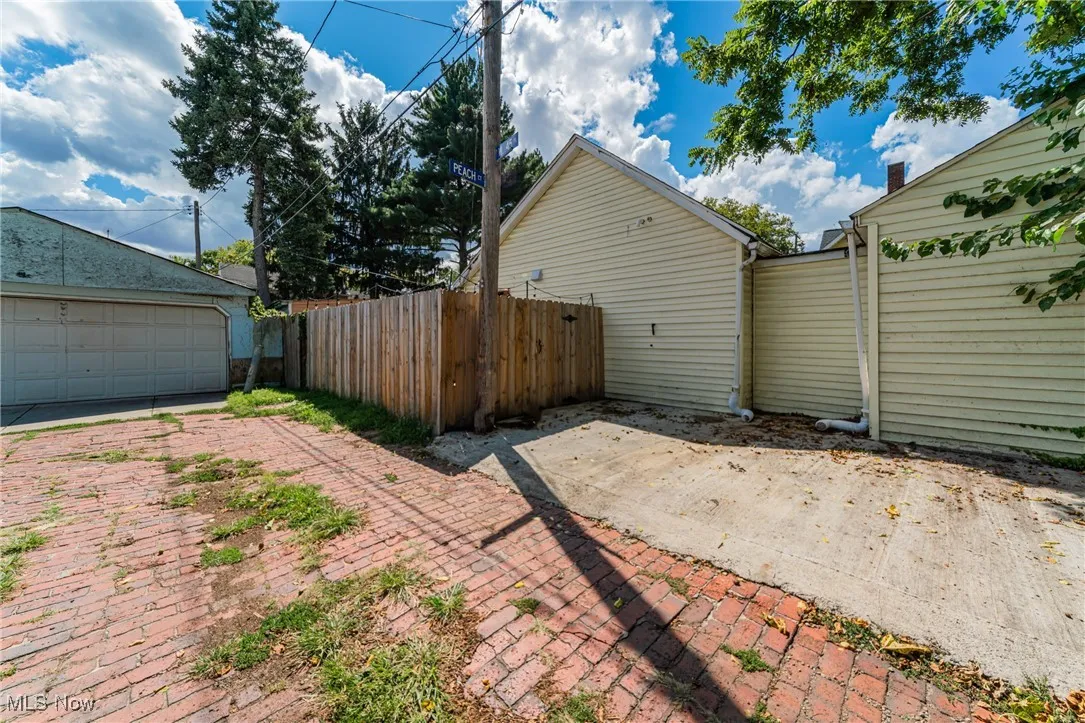 View of property exterior featuring a patio and a garage