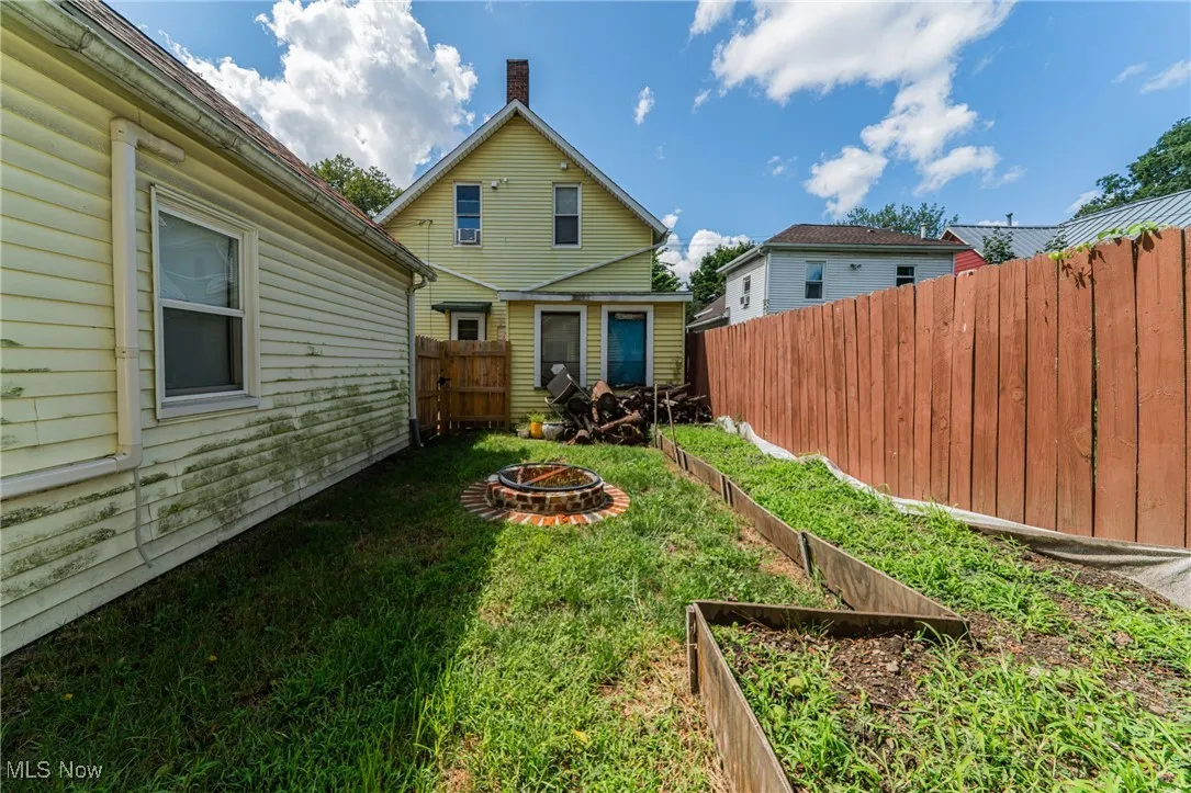 View of yard with an outdoor fire pit and a vegetable garden