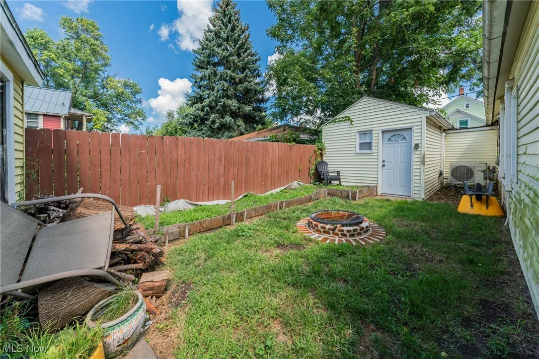 View of yard with an outbuilding and an outdoor fire pit