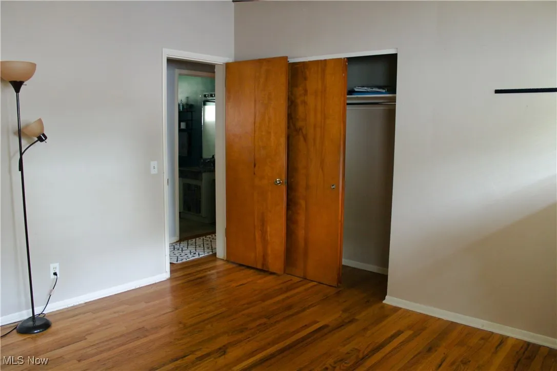 Master bedroom with wood finished floors and a closet