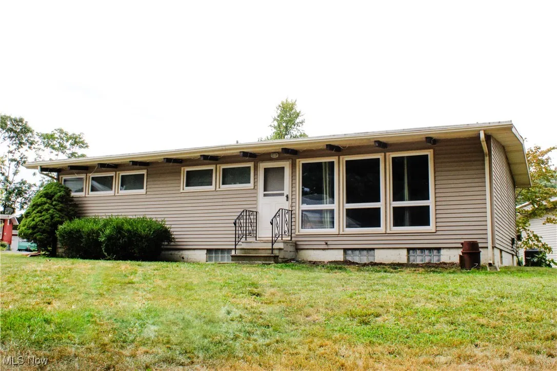 Back of property featuring a lawn