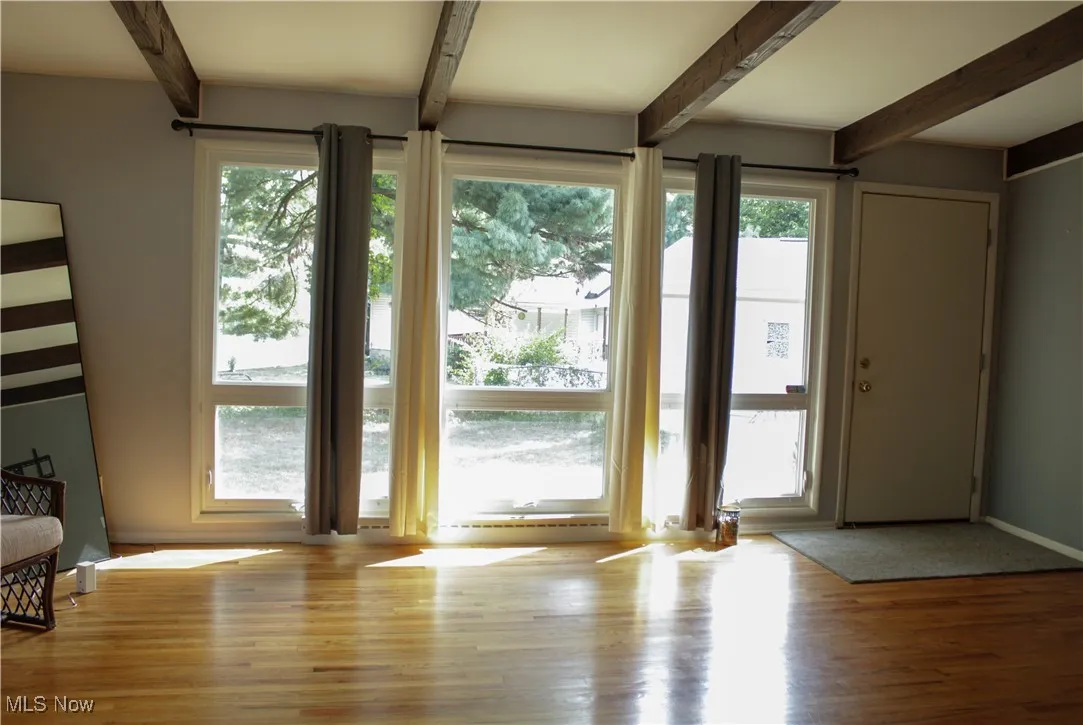 Living room with beamed ceiling and light wood finished floors