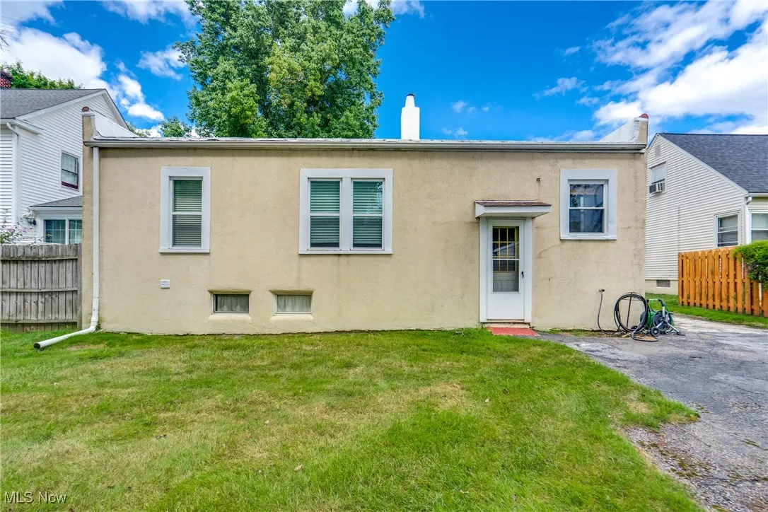Rear view of property with a chimney and stucco siding