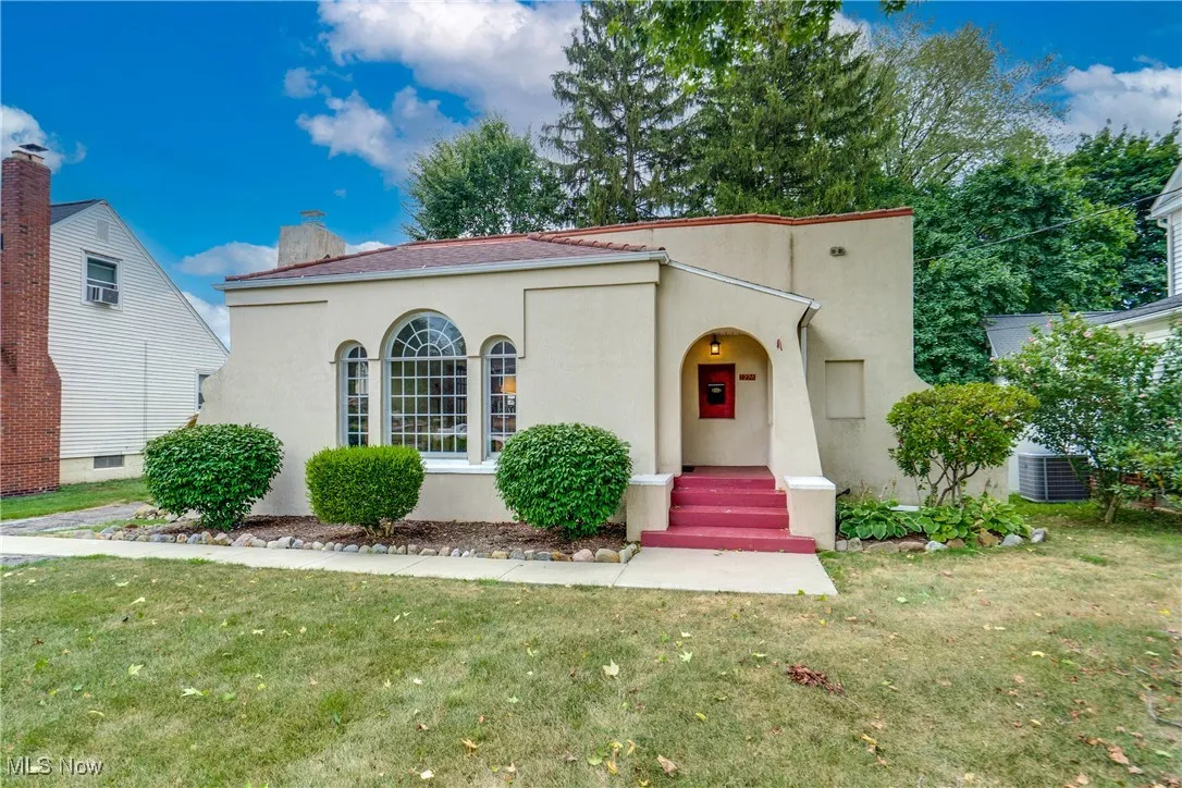 Mediterranean / spanish-style home featuring stucco siding, a front yard, a chimney, and a porch