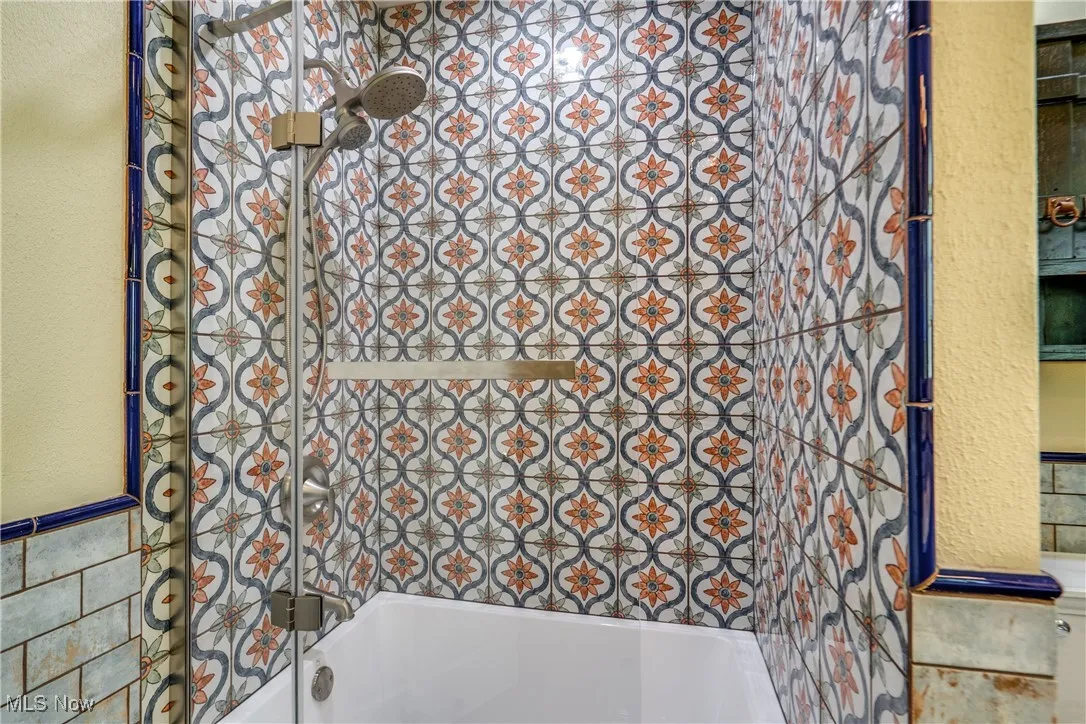 Bathroom with  shower combination and tile walls