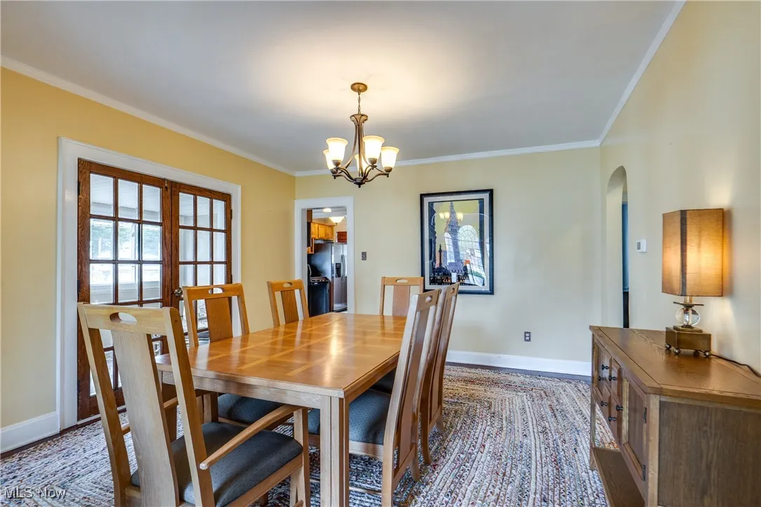 Dining room with ornamental molding and a chandelier