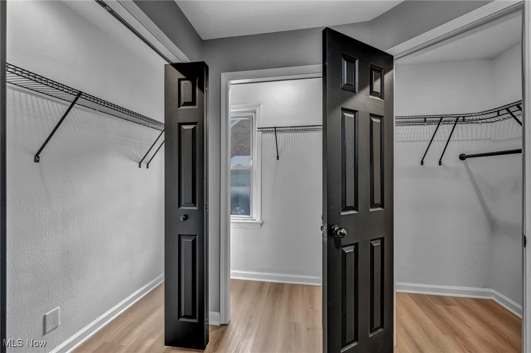 Spacious closet featuring light wood-style flooring