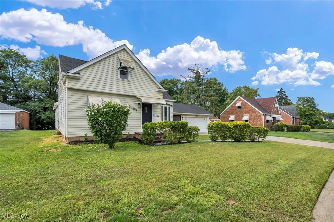 View of front of property featuring a front lawn and a garage