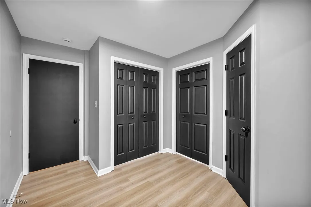 Foyer with light wood finished floors and baseboards