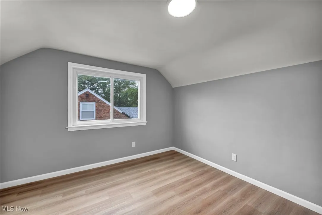 Additional living space with lofted ceiling and light wood-type flooring
