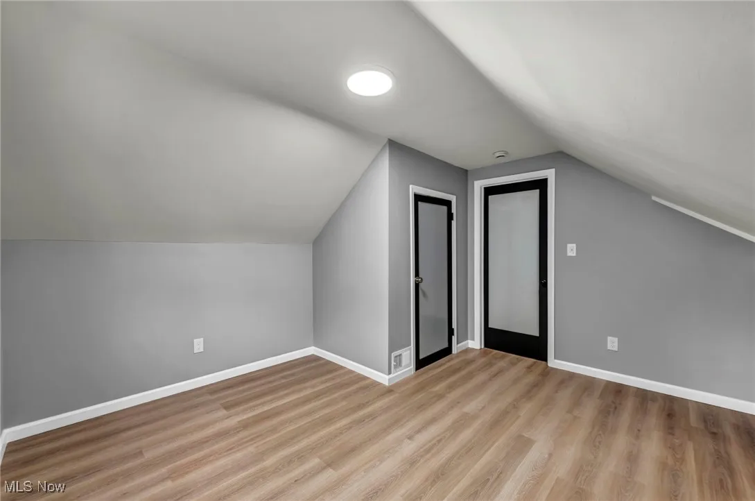 Bonus room featuring lofted ceiling and light wood-type flooring