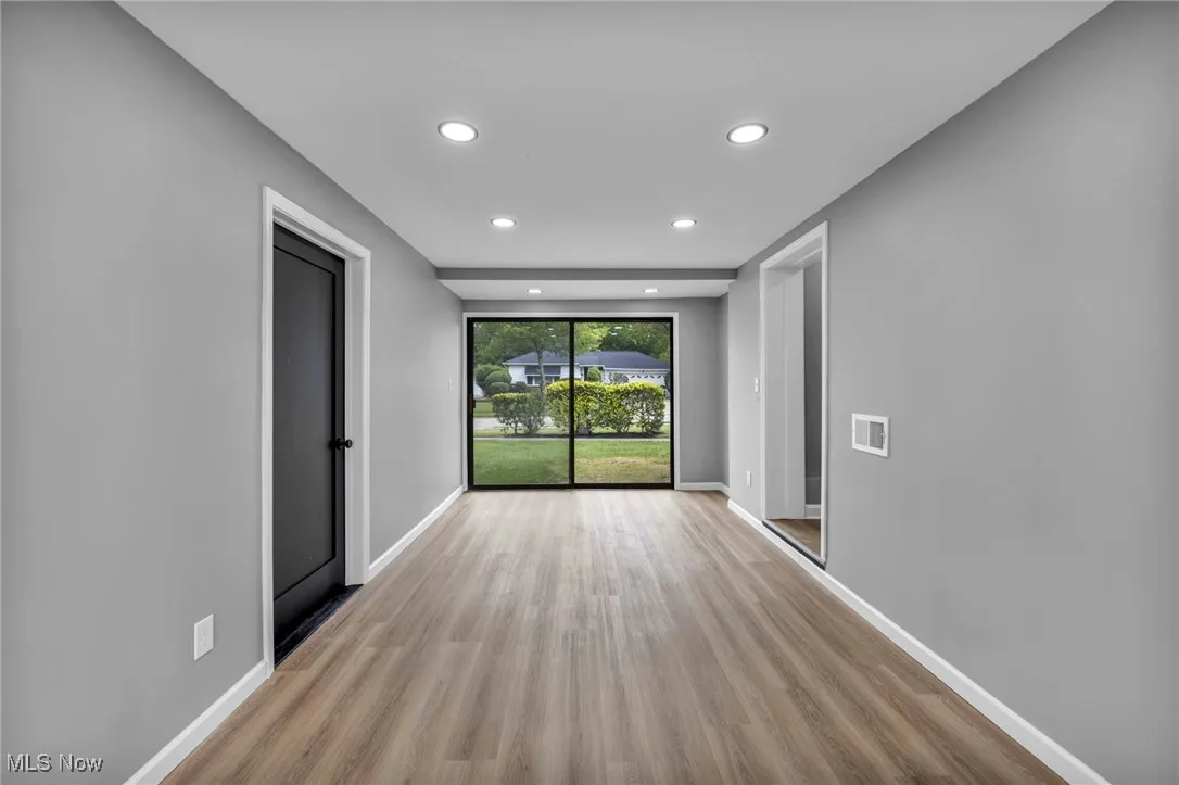 Empty room featuring light wood-style flooring and recessed lighting
