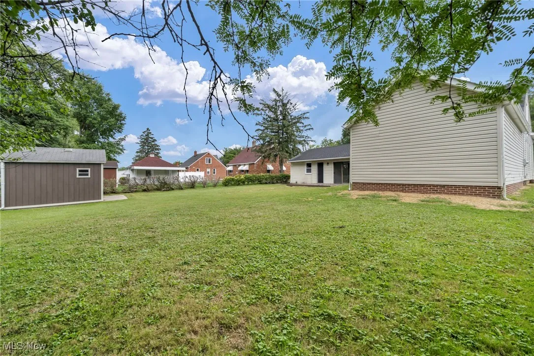 View of green lawn featuring a storage unit