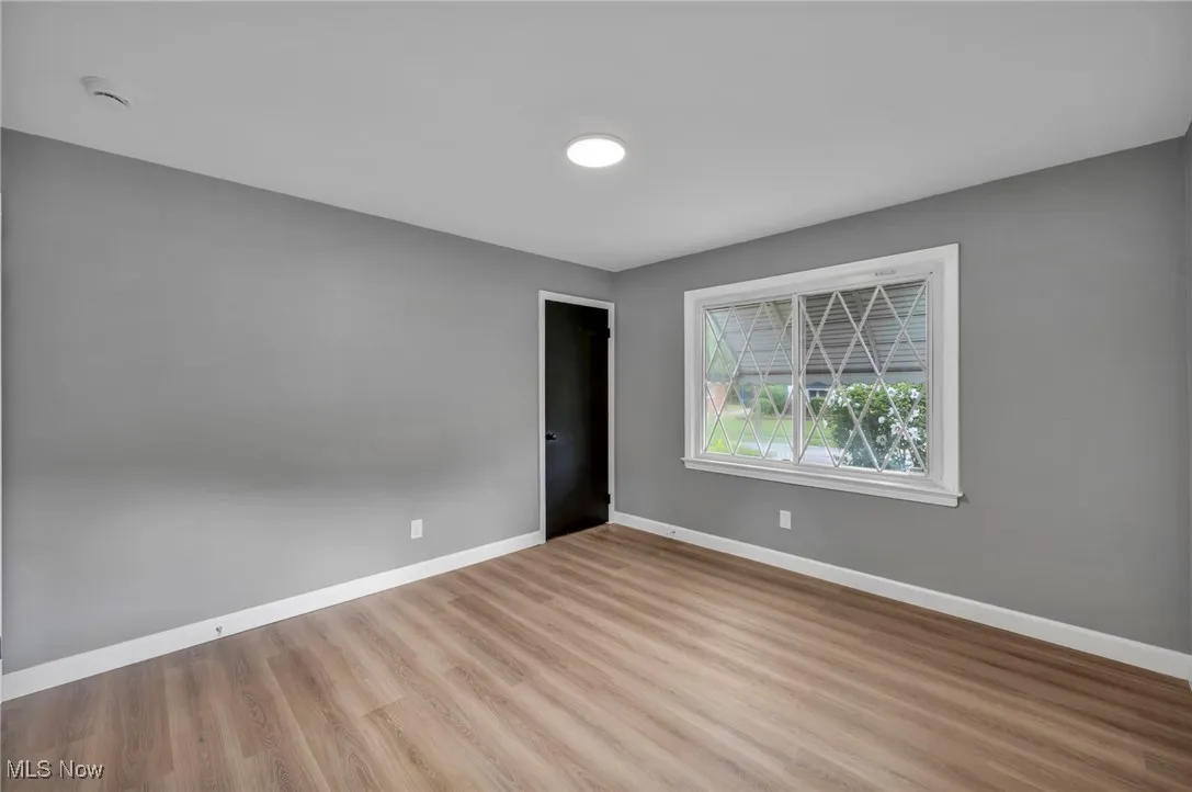 Unfurnished bedroom with baseboards and wood finished floors