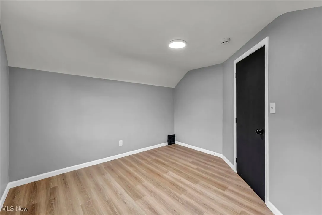 Bonus room with lofted ceiling and light wood-style floors