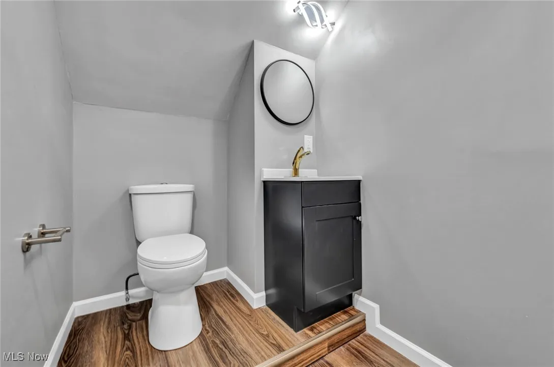 Half bathroom with vanity and wood finished floors