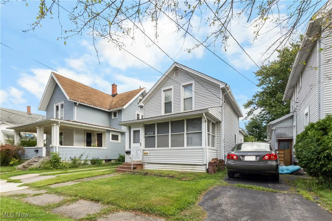 View of front of home with a sunroom and a front lawn