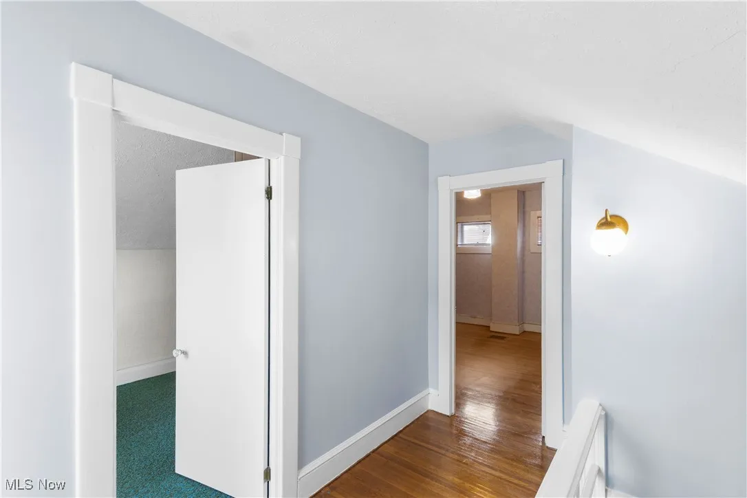 Corridor with baseboards and wood finished floors