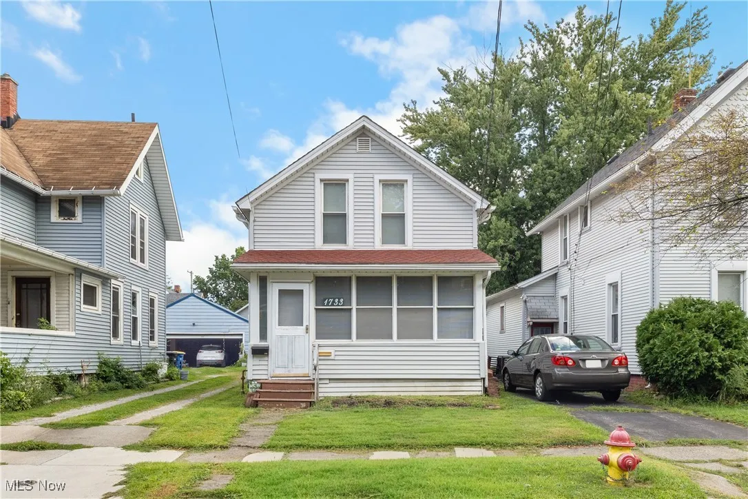 Traditional style home with a front lawn, a garage, and entry steps