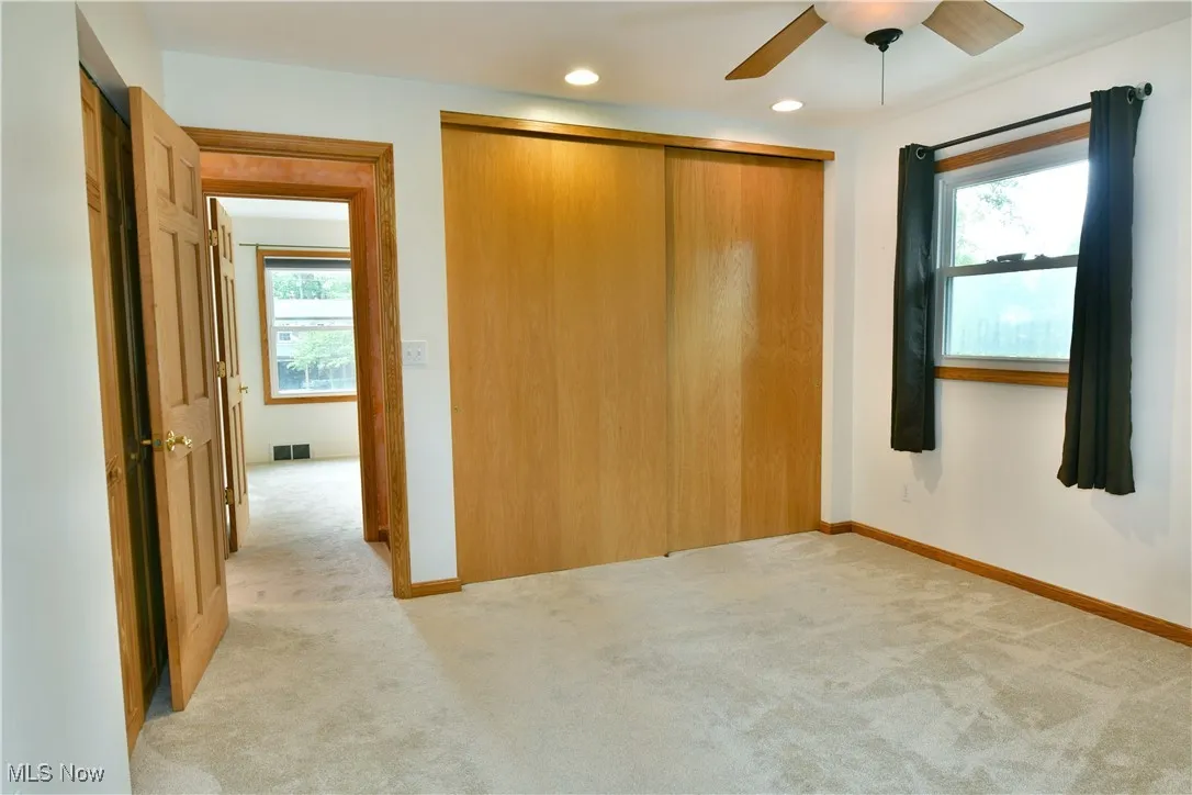 Unfurnished bedroom with multiple windows, light carpet, a closet, ceiling fan, and recessed lighting