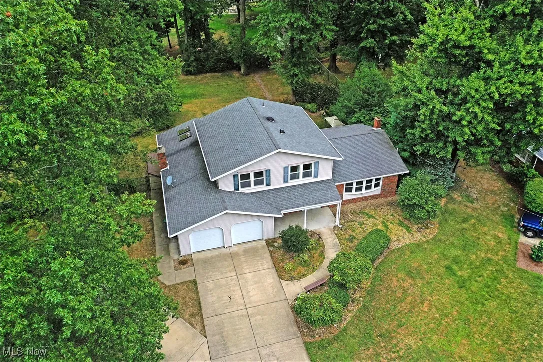 View from above of property with a tree filled landscape