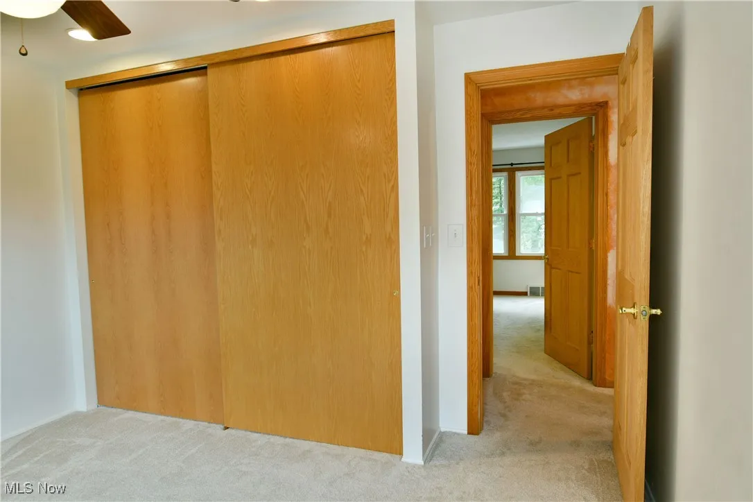 Hallway featuring light carpet