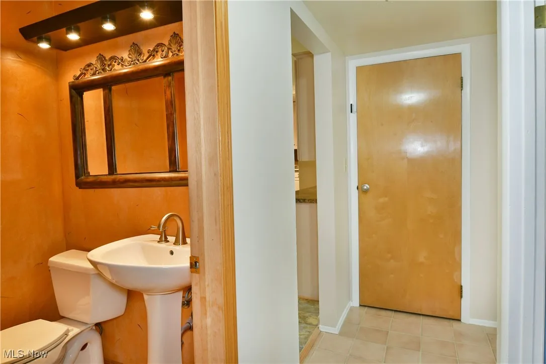 Bathroom featuring light tile patterned flooring and toilet