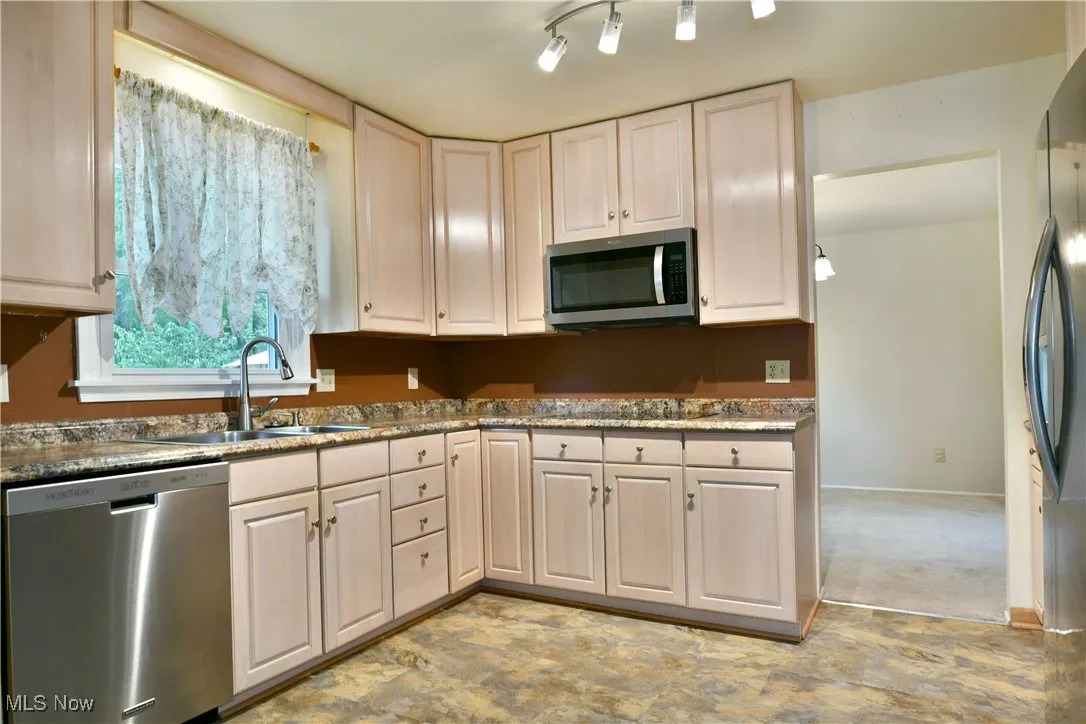 Kitchen with appliances with stainless steel finishes and dark stone countertops