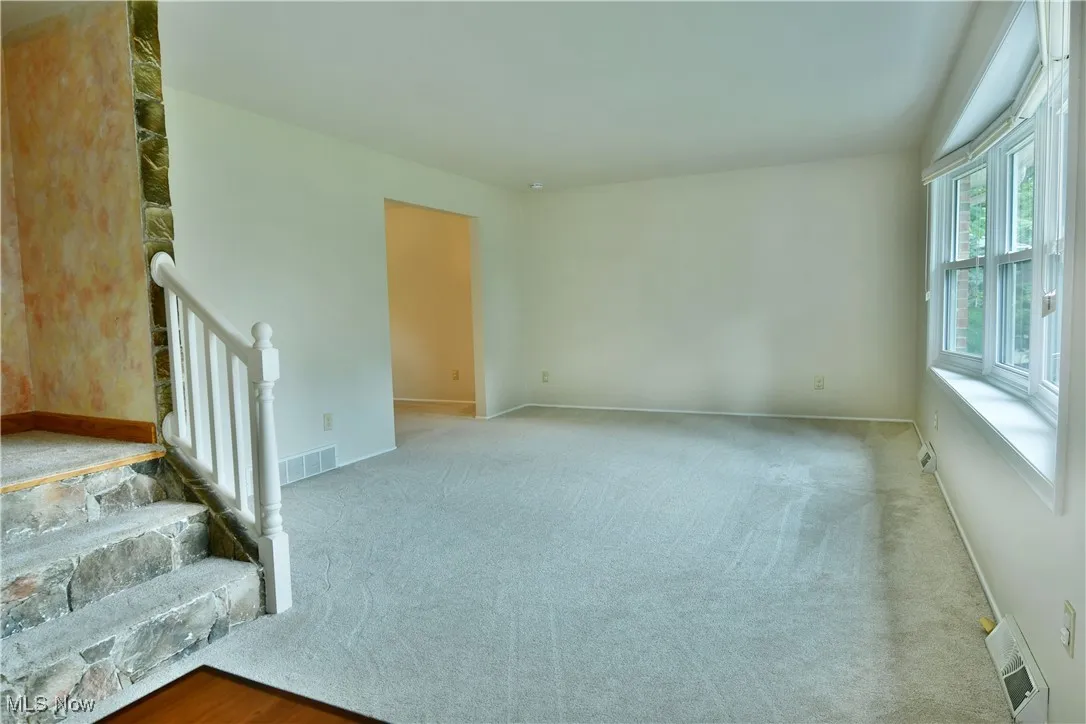 Empty room with carpet and baseboards