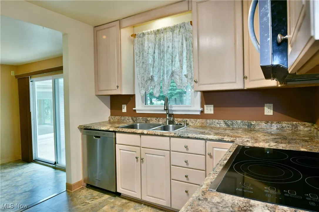 Kitchen with appliances with stainless steel finishes and white cabinetry