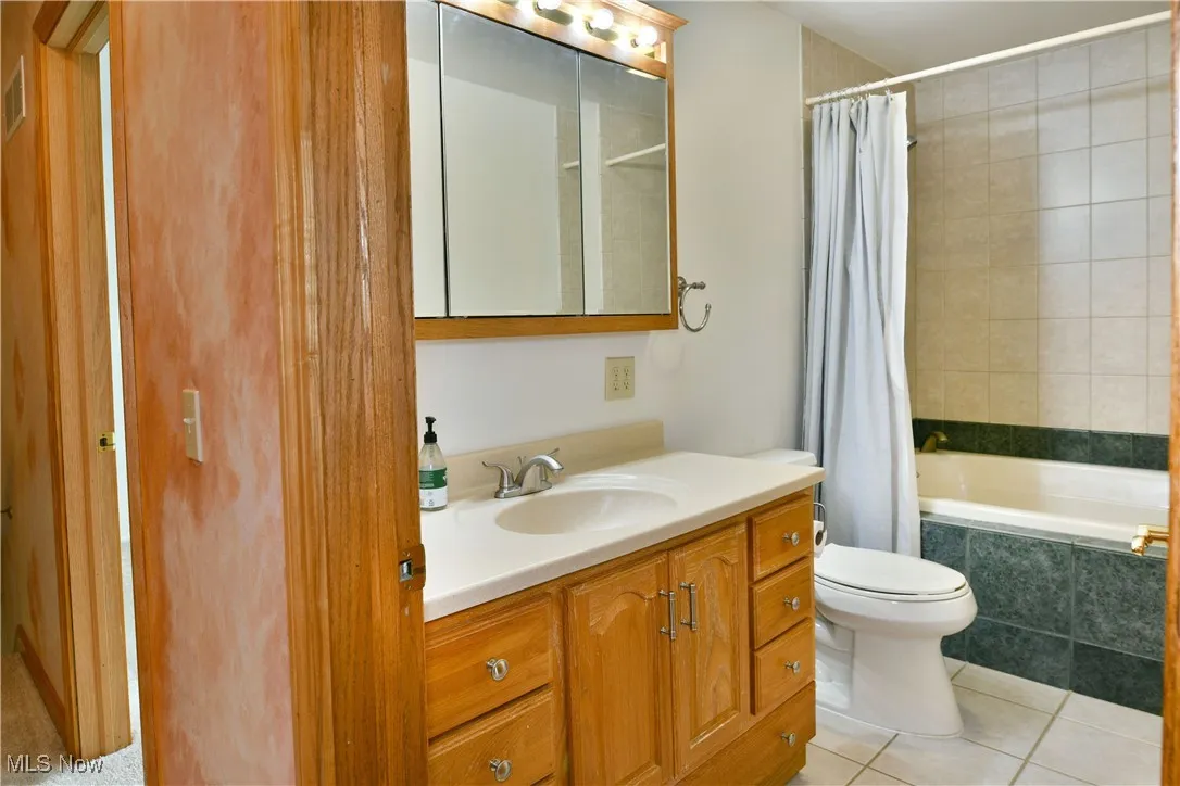 Full bathroom featuring vanity, tiled shower / bath combo, and light tile patterned floors