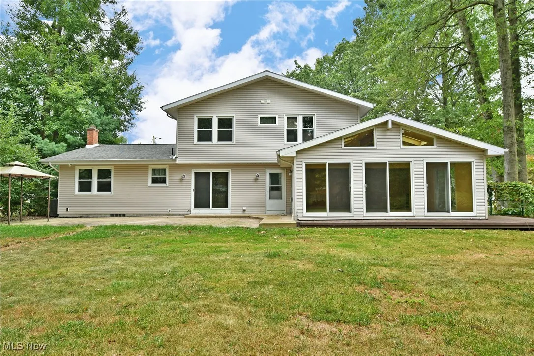 Rear view of house with a yard, a chimney, and a patio area