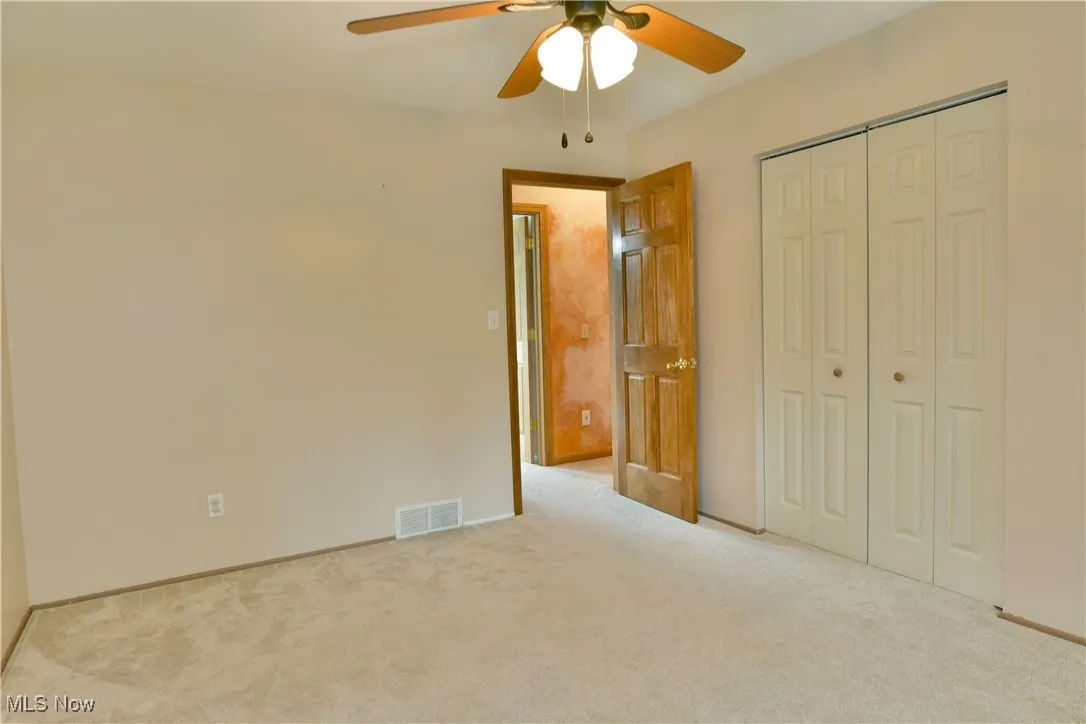 Unfurnished bedroom with a closet, carpet flooring, and ceiling fan