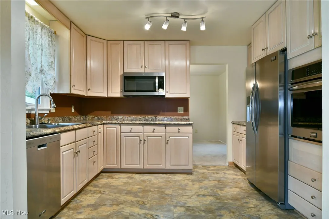 Kitchen featuring stainless steel appliances and dark stone counters