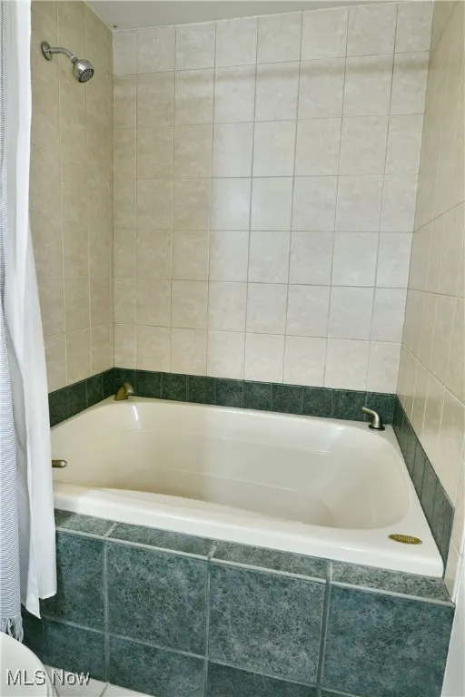 Bathroom with tiled shower / bath and tile walls