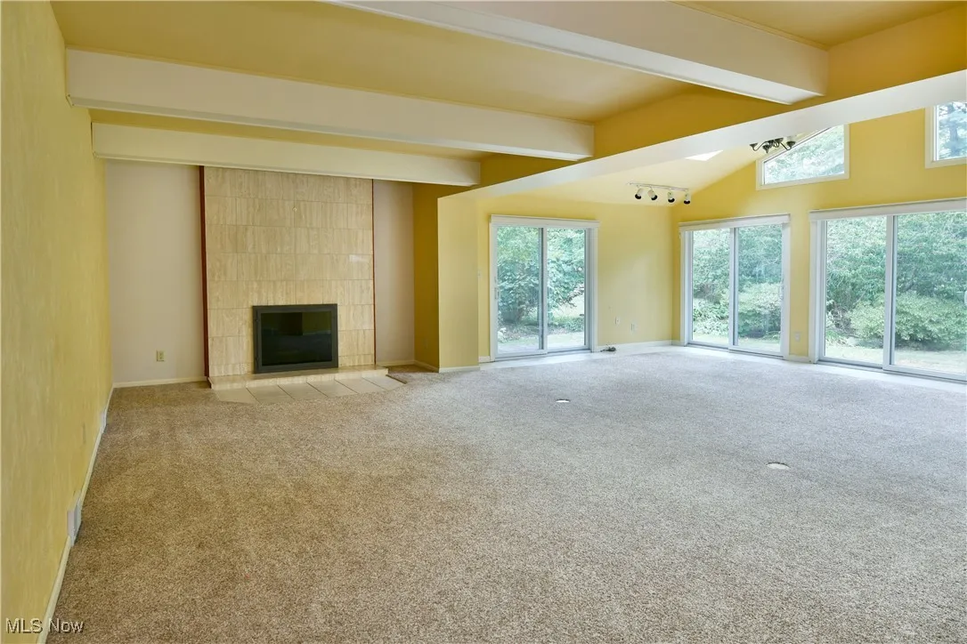 Unfurnished living room with a fireplace and carpet