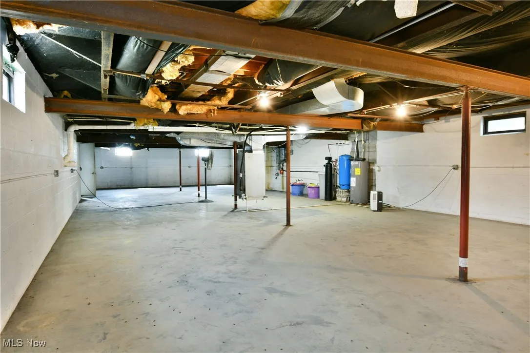 Basement featuring water heater and heating unit