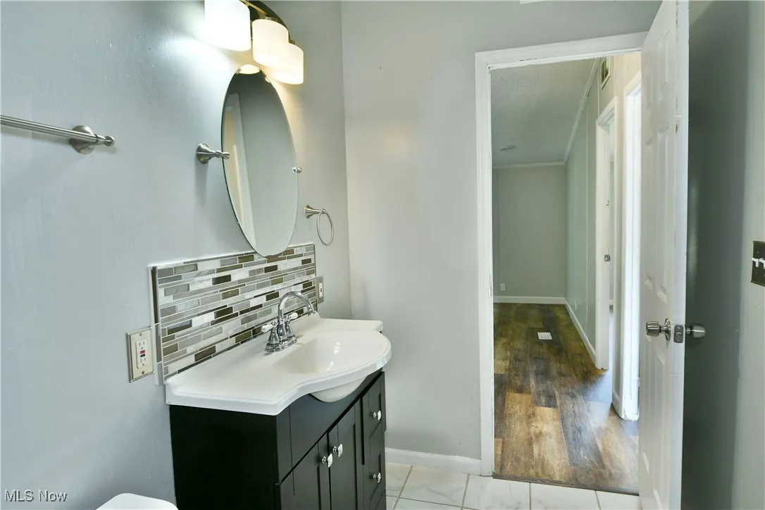 Half bathroom featuring tasteful backsplash and vanity