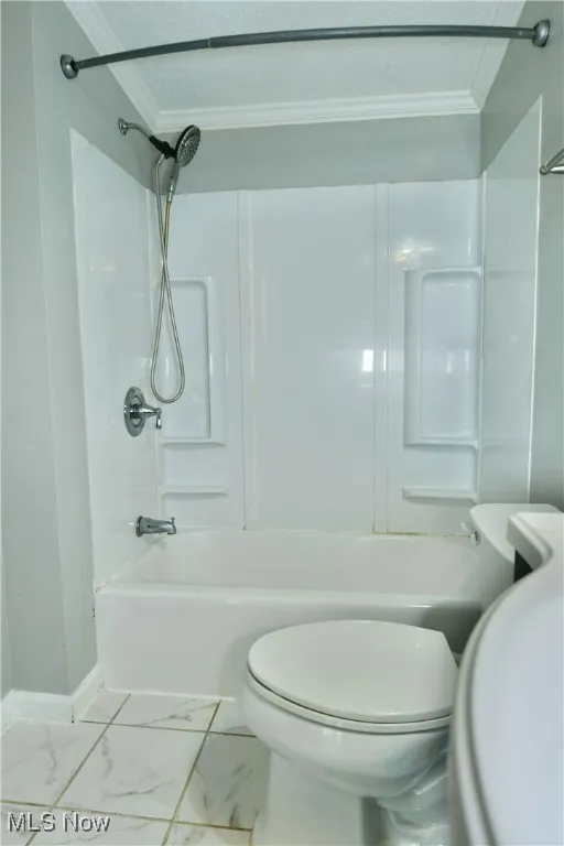 Full bathroom with shower / washtub combination, crown molding, marble look tile flooring, and a textured ceiling