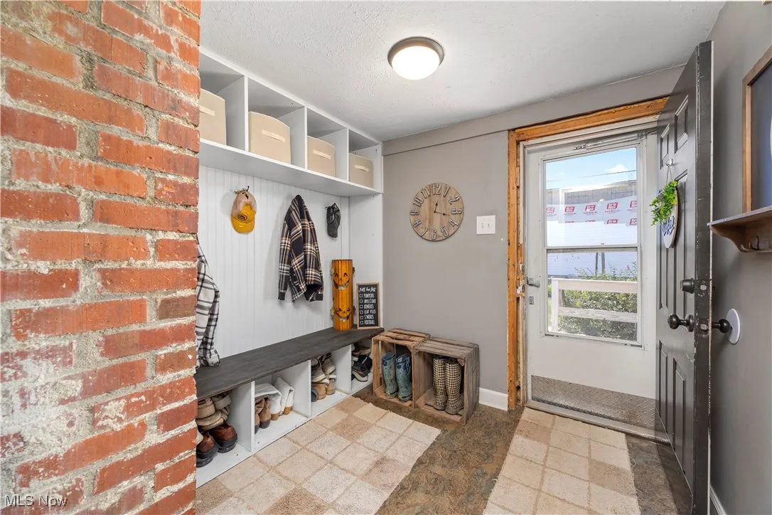 Mudroom with a textured ceiling and baseboards